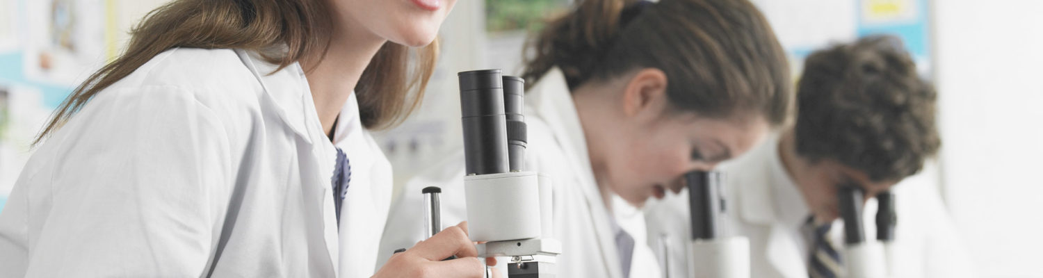 Girl using a microscope in science class