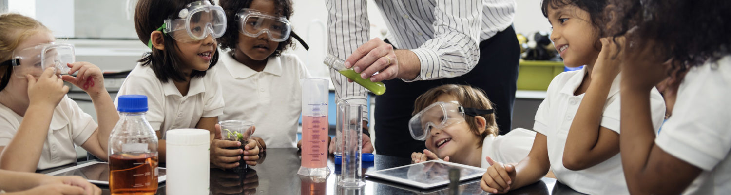 A teacher showing young students an experiment in science class