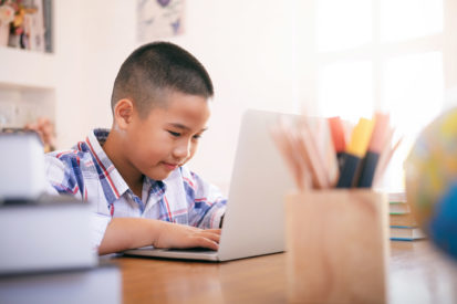A young boy typing on a computer