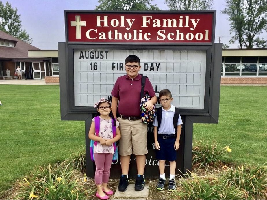 The Lopez children in front of Holy Family Catholic School